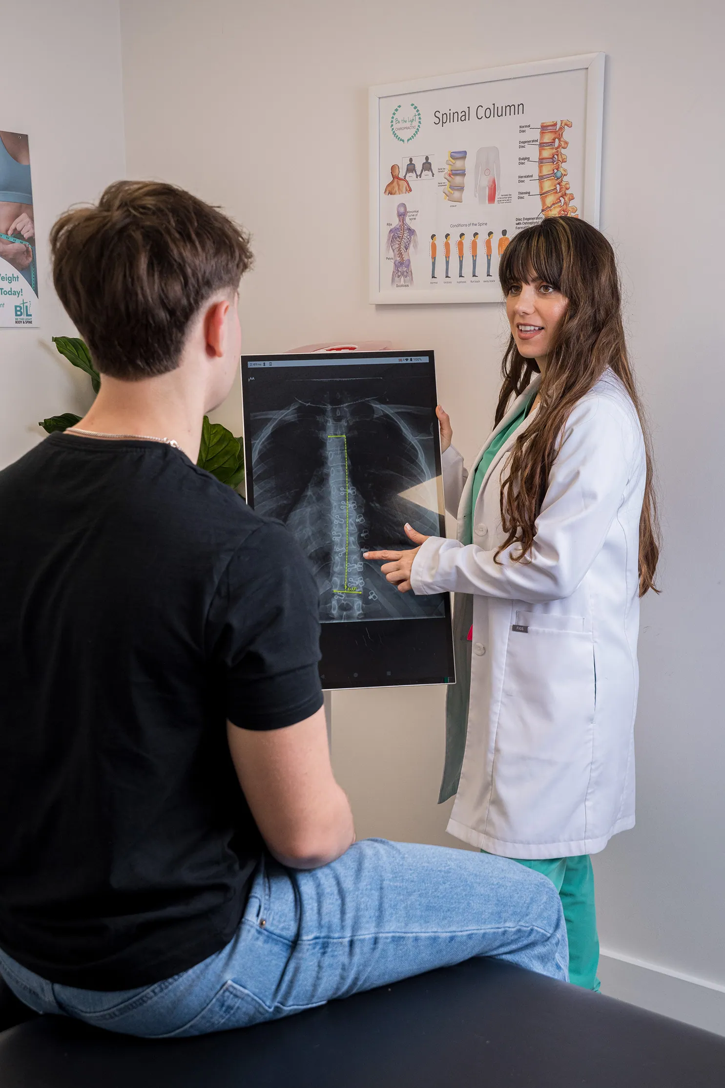 Doctor reviewing a digital spine X-ray with a patient